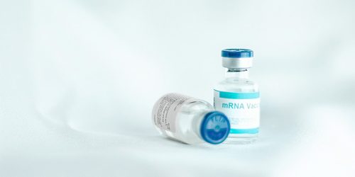 two mrna vaccines on a white background, with a blue and white label
