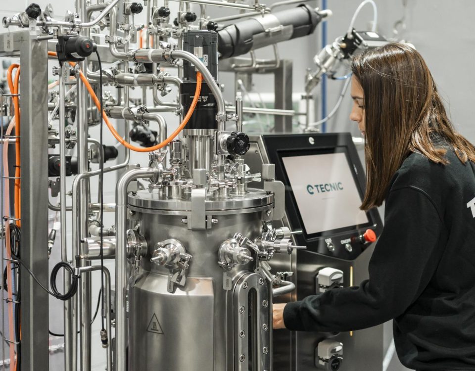 A woman from behind working on biotechnology professions related to bioprocess equipment, specifically bioreactors.